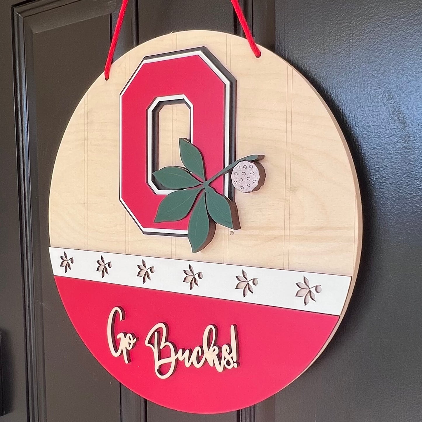 Ohio state buckeyes door hanger with Go Bucks and the block o with buckeye leaf logo.