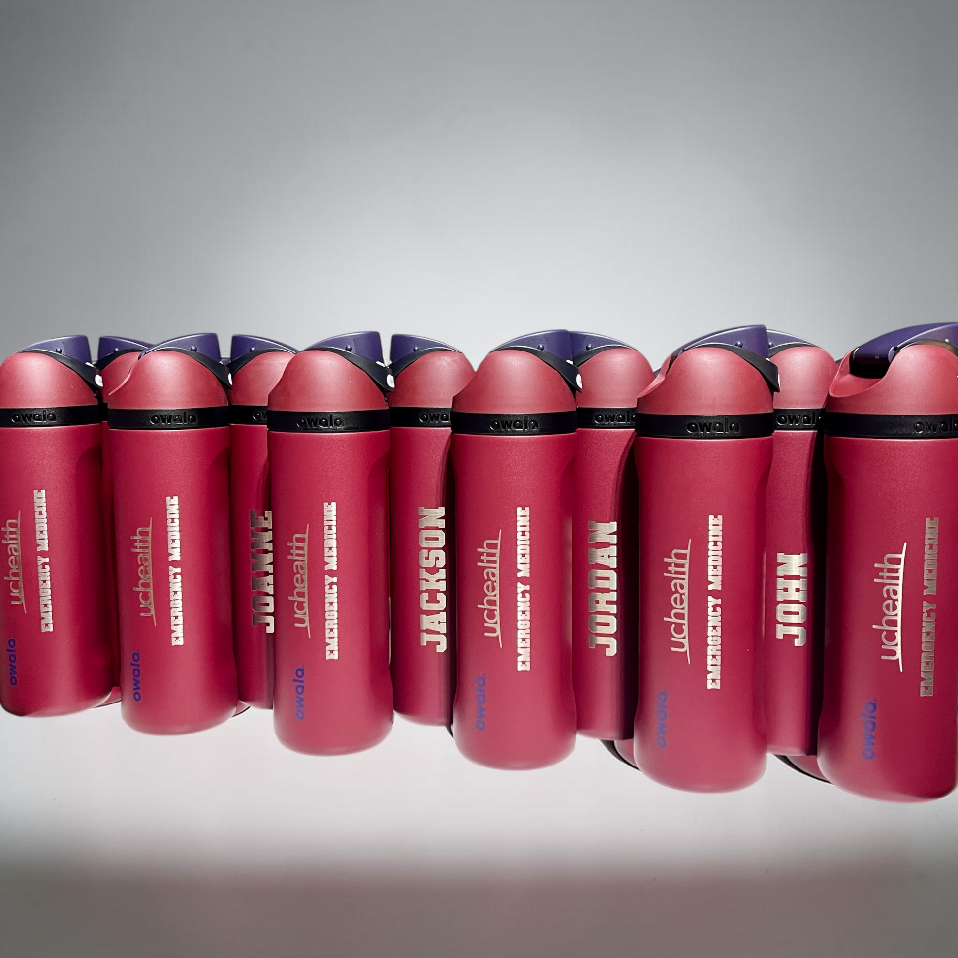 Owala water bottles with personalized names on one side and UCHealth and emergency medicine on the other side