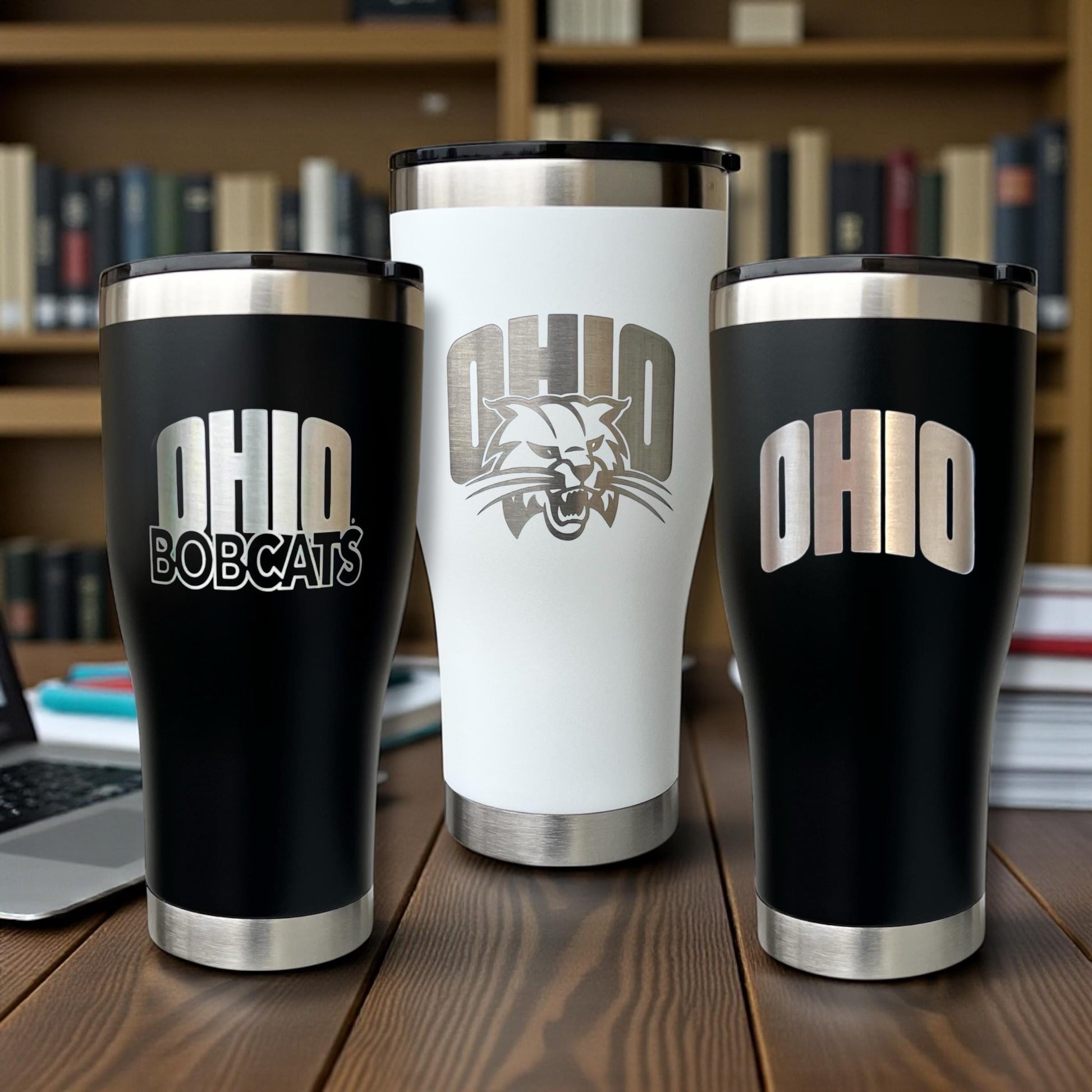 Three insulated tumblers with 'OHIO' branding on a wooden surface.