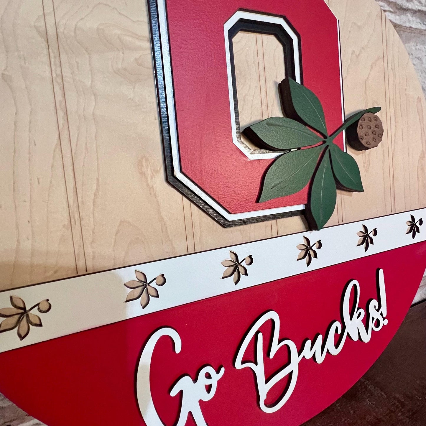 Ohio state buckeyes door hanger with Go Bucks and the block o with buckeye leaf logo.