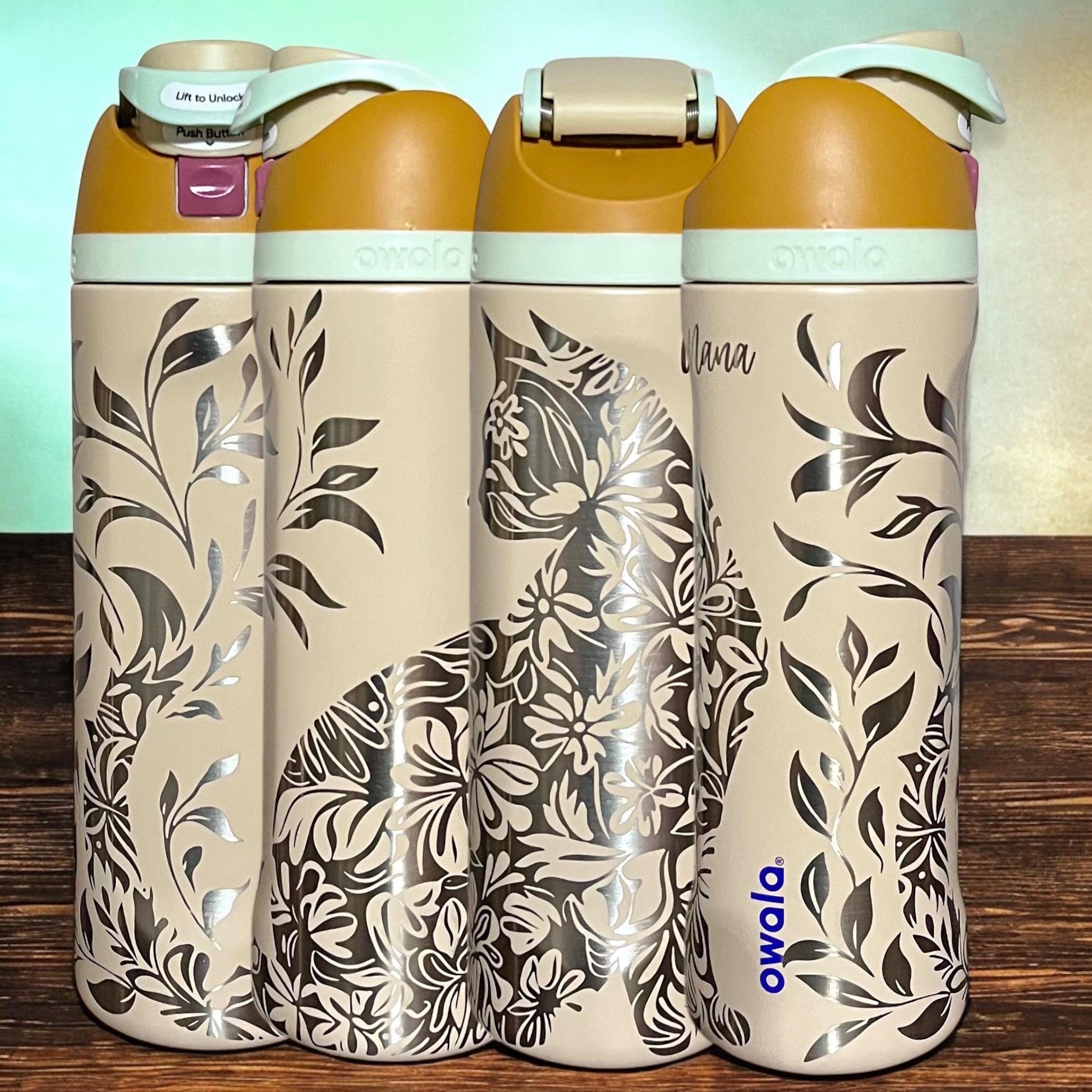 Owala Freesip 24oz water bottle with intricate full-wrap detailed floral cat engraving in water in the desert color